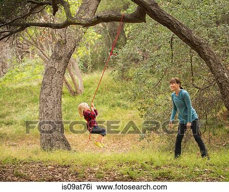 Mother pushing son on tree swing View Large Photo Image Stock Image - Mother pushing son on tree swing. Fotosearch