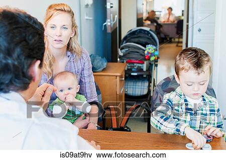 Mother sitting with two children, having discussion with doctor View Large Photo Image Stock Photo - Mother sitting with two children, having discussion with doctor. Fotosearch