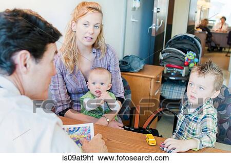 Mother sitting with two children, having discussion with doctor View Large Photo Image Stock Photograph - Mother sitting with two children, having discussion with doctor. Fotosearch