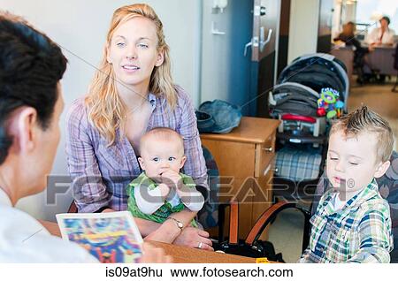 Mother sitting with two children, having discussion with doctor View Large Photo Image Stock Photograph - Mother sitting with two children, having discussion with doctor. Fotosearch