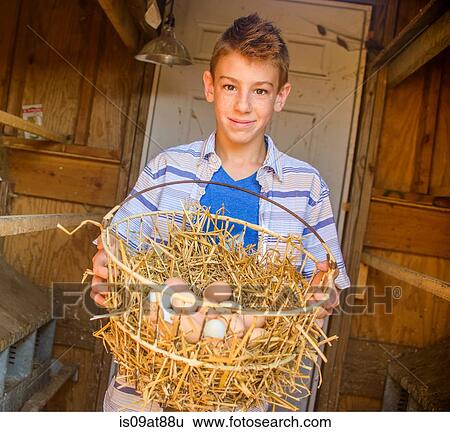 Portrait of boy carrying basket of eggs in hen house View Large Photo Image Stock Photograph - Portrait of boy carrying basket of eggs in hen house. Fotosearch