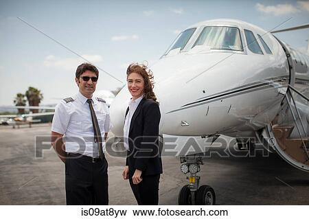 Stock Photo - Portrait of female businesswoman and pilot of private jet at airport. Fotosearch