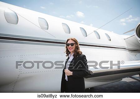 Portrait of female businesswoman and private jet at airport View Large Photo Image Stock Photo - Portrait of female businesswoman and private jet at airport. Fotosearch