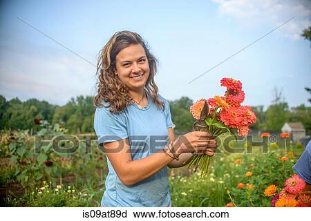 Portrait of female farm worker holding a bunch of fresh cut flowers View Large Photo Image Stock Image - Portrait of female farm worker holding a bunch of fresh cut flowers. Fotosearch