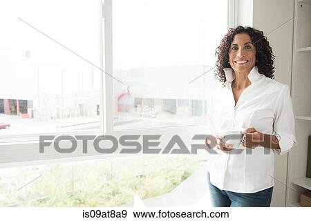 Portrait of mature woman drinking coffee at apartment window View Large Photo Image Stock Photo - Portrait of mature woman drinking coffee at apartment window. Fotosearch