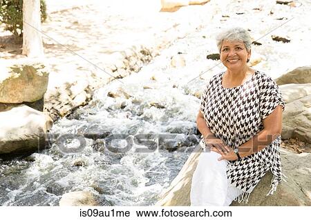Portrait of mature woman sitting on rock, outdoors View Large Photo Image Stock Image - Portrait of mature woman sitting on rock, outdoors. Fotosearch
