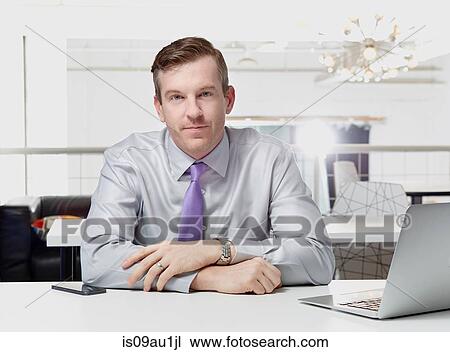 Portrait of mid adult businessman sitting at desk View Large Photo Image Stock Image - Portrait of mid adult businessman sitting at desk. Fotosearch