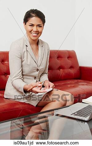 Portrait of mid adult businesswoman sitting on sofa, using laptop View Large Photo Image Stock Image - Portrait of mid adult businesswoman sitting on sofa, using laptop. Fotosearch
