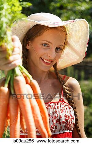 Portrait of mid adult woman in garden, holding bunch of carrots View Large Photo Image Stock Photograph - Portrait of mid adult woman in garden, holding bunch of carrots. Fotosearch