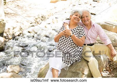 Portrait of senior couple sitting on rock, outdoors View Large Photo Image Stock Image - Portrait of senior couple sitting on rock, outdoors. Fotosearch