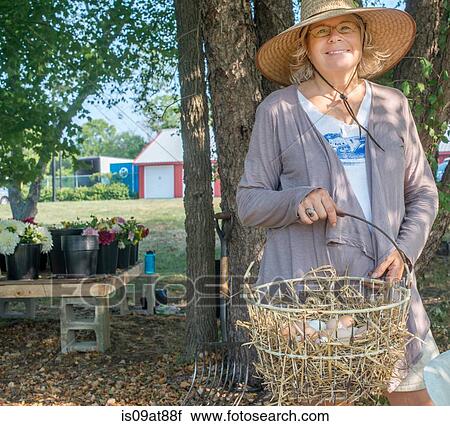 Portrait of senior female farmer carrying basket of eggs View Large Photo Image Stock Image - Portrait of senior female farmer carrying basket of eggs. Fotosearch