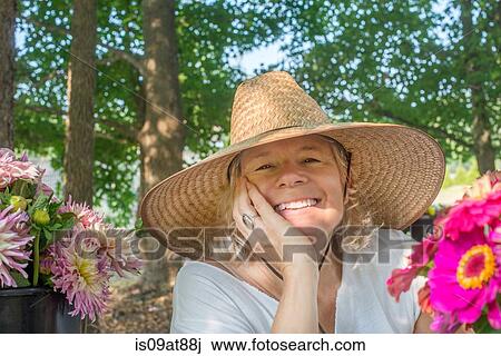 Portrait of senior female farmer wearing sun hat with cut flowers View Large Photo Image Stock Image - Portrait of senior female farmer wearing sun hat with cut flowers. Fotosearch