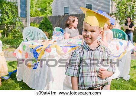 Portrait of young boy at kindergarten graduation, wearing paper mortar board View Large Photo Image Picture - Portrait of young boy at kindergarten graduation, wearing paper mortar board. Fotosearch