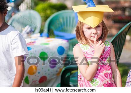 Portrait of young girl at kindergarten graduation, wearing paper mortar board View Large Photo Image Stock Image - Portrait of young girl at kindergarten graduation, wearing paper mortar board. Fotosearch