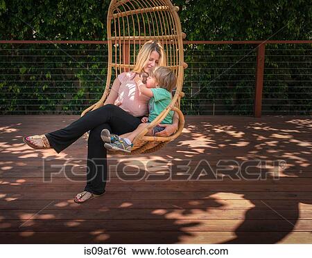 Pregnant woman and son, relaxing in garden swing chair View Large Photo Image Stock Photograph - Pregnant woman and son, relaxing in garden swing chair. Fotosearch