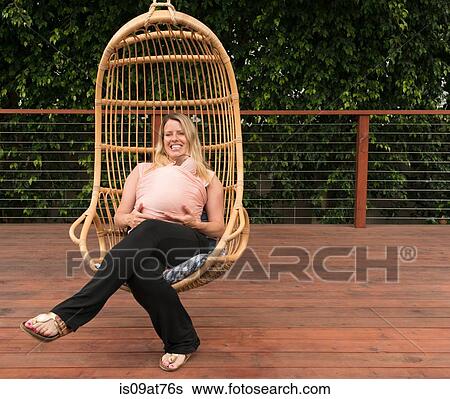 Pregnant woman relaxing in garden swing chair View Large Photo Image Stock Photograph - Pregnant woman relaxing in garden swing chair. Fotosearch