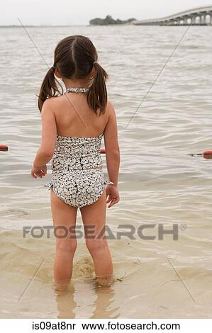 Rear view of girl looking out at ocean, Sanibel Island, Pine Island Sound, Florida, USA View Large Photo Image Stock Photography - Rear view of girl looking out at ocean, Sanibel Island, Pine Island Sound, Florida, USA. Fotosearch