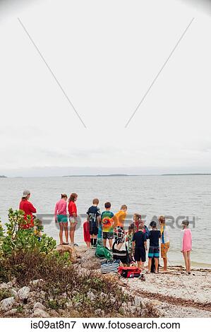 Rear view of large group of children on beach, Sanibel Island, Pine Island Sound, Florida, USA View Large Photo Image Stock Photo - Rear view of large group of children on beach, Sanibel Island, Pine Island Sound, Florida, USA. Fotosearch