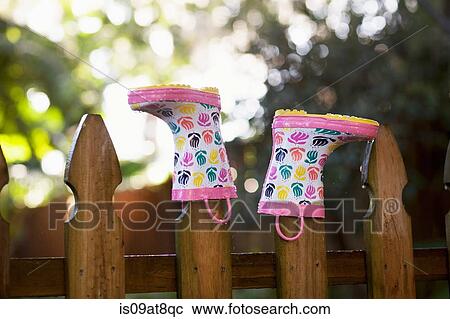 Rubber boots, upturned, on wooden fence posts View Large Photo Image Stock Image - Rubber boots, upturned, on wooden fence posts. Fotosearch