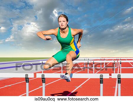 Runner jumping over hurdle on track View Large Photo Image Stock Photography - Runner jumping over hurdle on track. Fotosearch