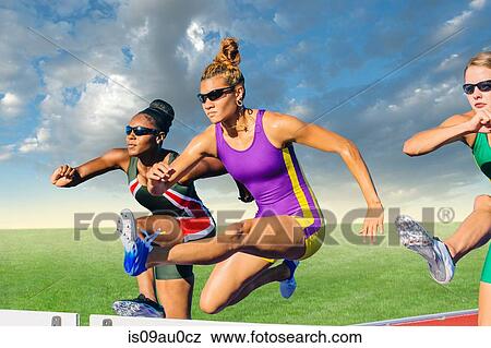 Stock Photo - Runners jumping over hurdle on track. Fotosearch