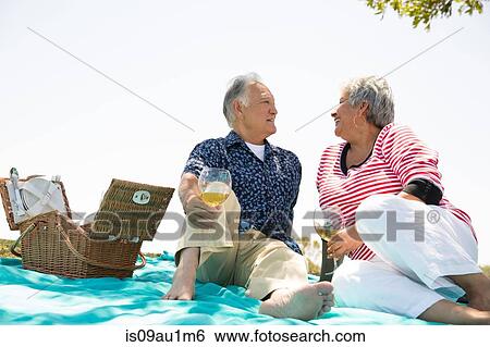 Stock Photograph - Senior couple having picnic outdoors. Fotosearch