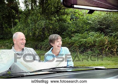 Senior couple sitting beside camper van holding map View Large Photo Image Stock Image - Senior couple sitting beside camper van holding map. Fotosearch