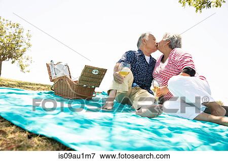 Senior couple sitting on picnic blanket, kissing View Large Photo Image Stock Photo - Senior couple sitting on picnic blanket, kissing. Fotosearch