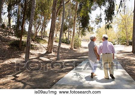 Senior couple walking hand in hand, outdoors, rear view View Large Photo Image Stock Image - Senior couple walking hand in hand, outdoors, rear view. Fotosearch