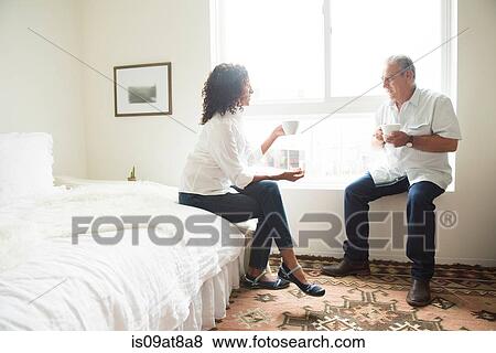 Senior man and wife drinking coffee in bedroom View Large Photo Image Stock Photo - Senior man and wife drinking coffee in bedroom. Fotosearch