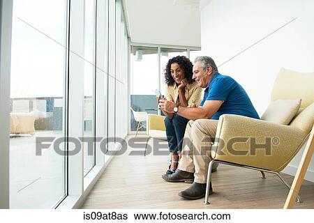 Senior man and wife reading smartphone texts View Large Photo Image Stock Photograph - Senior man and wife reading smartphone texts. Fotosearch