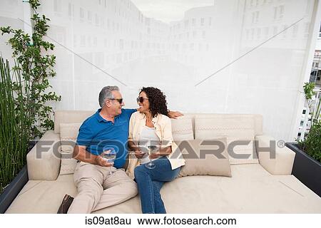 Senior man and wife sitting on patio sofa View Large Photo Image Stock Photograph - Senior man and wife sitting on patio sofa. Fotosearch