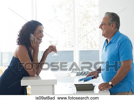 Senior man and wife using smartphone at kitchen counter View Large Photo Image Stock Image - Senior man and wife using smartphone at kitchen counter. Fotosearch