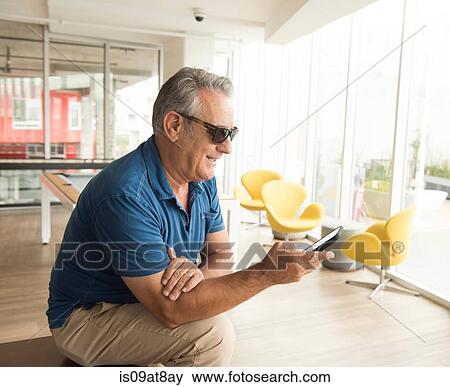 Senior man wearing sunglasses reading smartphone text View Large Photo Image Stock Photo - Senior man wearing sunglasses reading smartphone text. Fotosearch