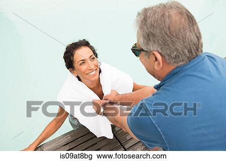 Senior man wrapping towel around wife from poolside View Large Photo Image Stock Image - Senior man wrapping towel around wife from poolside. Fotosearch