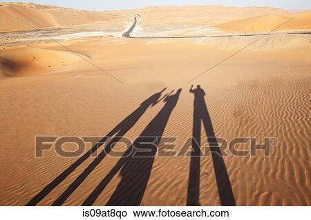 Shadows of three people on sand in desert, Liwa Oasis, Abu Dhabi, UAE View Large Photo Image Picture - Shadows of three people on sand in desert, Liwa Oasis, Abu Dhabi, UAE. Fotosearch