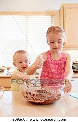 Siblings melting chocolate in mixing bowl View Large Photo Image Stock Image - Siblings melting chocolate in mixing bowl. Fotosearch