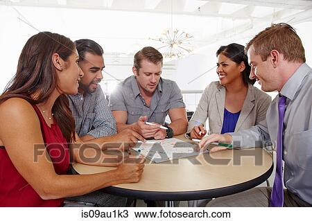 Stock Image - Small group of people having brainstorming business meeting. Fotosearch
