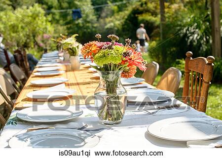 Stock Image - Table setting for large family at tomato eating festival. Fotosearch