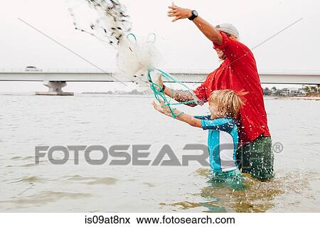 Teacher showing boy how to use cast net, Sanibel Island, Pine Island Sound, Florida, USA View Large Photo Image Stock Photo - Teacher showing boy how to use cast net, Sanibel Island, Pine Island Sound, Florida, USA. Fotosearch
