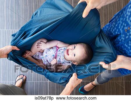 Stock Photography - Two women holding baby in blanket, overhead view. Fotosearch