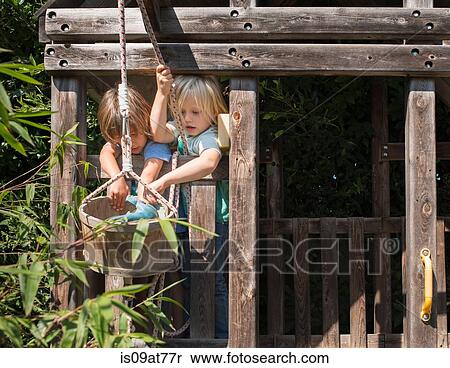 Stock Photography - Two young boys playing in tree house. Fotosearch