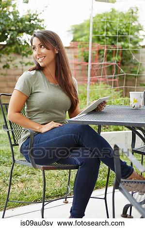 Stock Photo - Woman using digital tablet in garden. Fotosearch