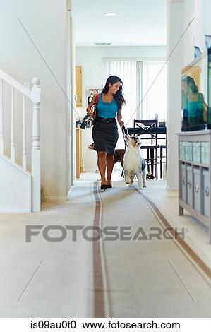 Woman walking down hallway, dog with her View Large Photo Image Stock Image - Woman walking down hallway, dog with her. Fotosearch