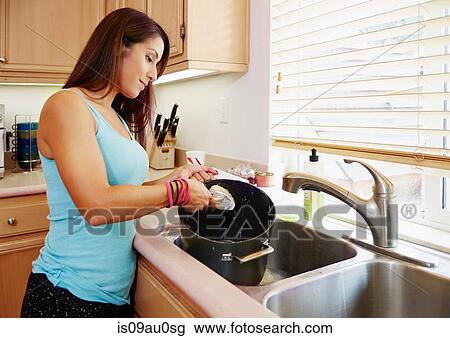 Woman washing pot in kitchen sink View Large Photo Image Stock Image - Woman washing pot in kitchen sink. Fotosearch