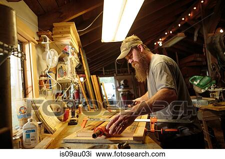 Stock Image - Wood artist working in workshop. Fotosearch