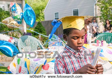 Young boy at kindergarten graduation, wearing paper mortar board, holding certificate View Large Photo Image Stock Photo - Young boy at kindergarten graduation, wearing paper mortar board, holding certificate. Fotosearch
