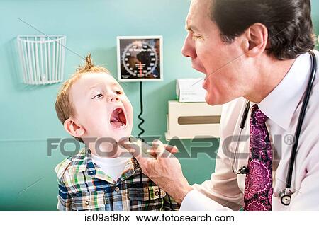 Young boy having check-up in doctor's office, doctor looking in boy's mouth View Large Photo Image Stock Photo - Young boy having check-up in doctor's office, doctor looking in boy's mouth. Fotosearch