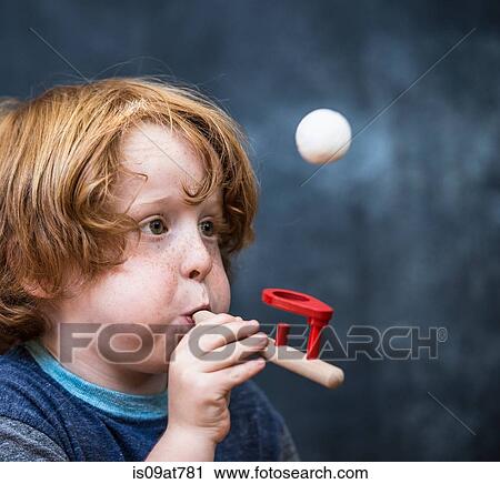 Young boy playing game, blowing ping pong ball in air View Large Photo Image Stock Image - Young boy playing game, blowing ping pong ball in air. Fotosearch
