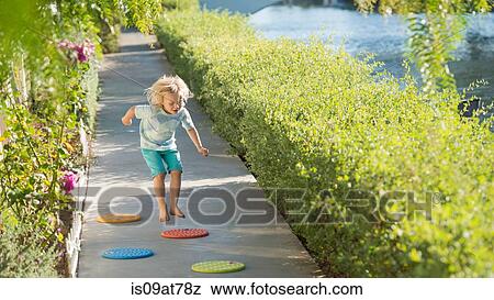 Young boy playing, jumping, outdoors View Large Photo Image Stock Photo - Young boy playing, jumping, outdoors. Fotosearch